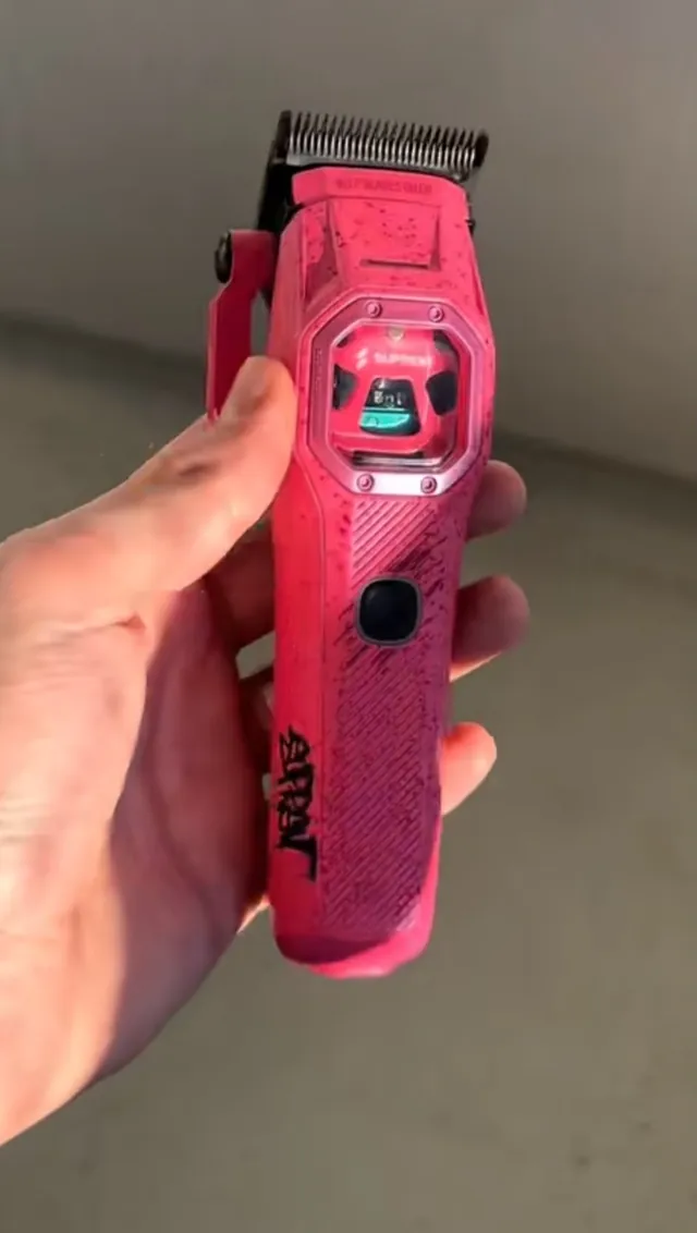 Máquina de corte profesional Suprem en color rosa, sujeta con la mano